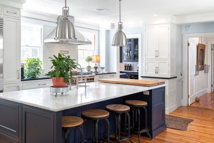 Kitchen with navy island and marble counters
